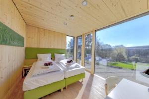 施泰瑙安德斯查瑟kleinHOTEL Steinau-Rabenstein GbR的一间卧室,里面有一张床和一扇大窗户。