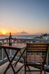 - une table en bois avec une bouteille de vin et un banc dans l'établissement Secret Garden Apartments, à Mykonos