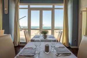 a table with wine glasses and a view of the ocean at Hotel Rex in Livorno