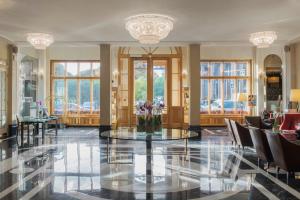 eine Lobby mit einem Tisch, Stühlen und Fenstern in der Unterkunft Angleterre Hotel in Sankt Petersburg