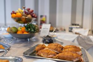 a table with a tray of pastries and fruit at Hotel Rex in Livorno