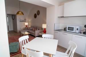 uma cozinha e sala de estar com uma mesa branca e cadeiras em CASA VALDES 16, APTO. 2 em Cáceres
