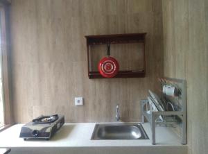 a kitchen with a sink and a microwave at Embang Homestay in Sidemen