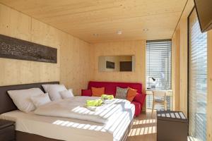 um quarto com uma cama e um sofá vermelho em kleinHOTEL Steinau-Rabenstein em Steinau an der Straße