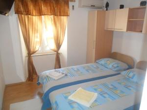 a bedroom with two beds and a window at Guest House Leon in Korčula