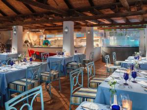 a dining room with blue tables and chairs at Hotel Jardín Tecina in Playa de Santiago