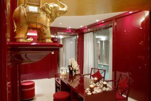 a red bathroom with an elephant statue on the wall at La Réserve Paris Hotel & Spa in Paris