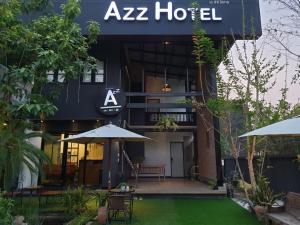 a zebra hotel with a table and umbrella in front of it at Azz Hotel in Chiang Mai