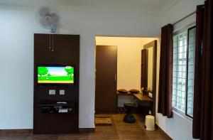 a living room with a tv in a room at THE SUVISTARA WAYANAD KERALA in Meenangadi