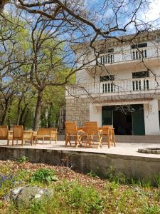 a group of wooden benches in front of a building at Vila Kajče in Omišalj