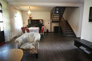 a living room with a table and chairs and a piano at Villa Bursztynek in Poddąbie