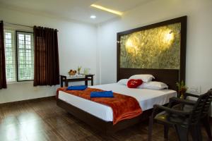 a bedroom with a bed with a large painting on the wall at THE SUVISTARA WAYANAD KERALA in Meenangadi