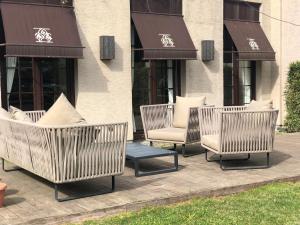 three chairs and a table in front of a building at Kemer Country Hotel İstanbul in Istanbul