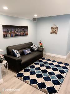 a living room with a black couch and a blue and white rug at Nice bedroom next fells point in Baltimore