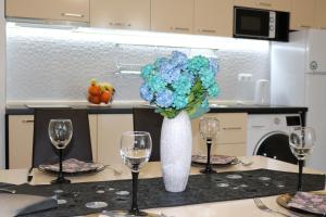 a table with two glasses and a vase with blue flowers at сем. Павлови in Obzor +16 photos