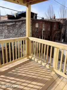 una terraza de madera con barandilla de madera en una casa en Nice bedroom next fells point en Baltimore