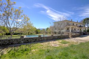 a stone fence in front of a house at aMatalasviñas in Piedralaves