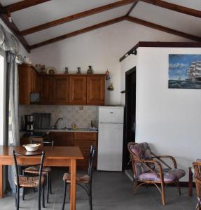 a kitchen with a table and chairs and a refrigerator at Patras Roof apartment in Agios Georgios Pagon