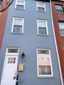 a gray building with white windows and a white door at Nice bedroom next fells point in Baltimore