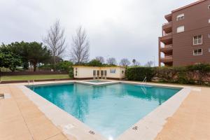 a swimming pool in front of a building at Três Castles Beach Apartment 3 in Portimão