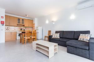 a living room with a couch and a table and a kitchen at Três Castles Beach Apartment 3 in Portimão