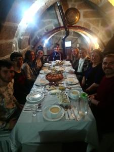 a group of people sitting around a table with food at Osmanoglu Hotel in Guzelyurt