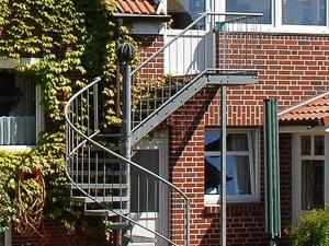 eine Metalltreppe an der Seite eines Backsteingebäudes in der Unterkunft Haus Kiebitznuest - Langeoog in Langeoog