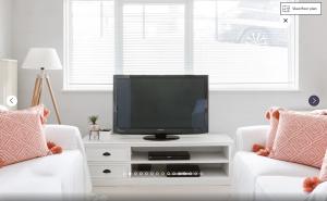 a living room with two white chairs and a television at Putney 1 Bed Apartment by BaseToGo in London