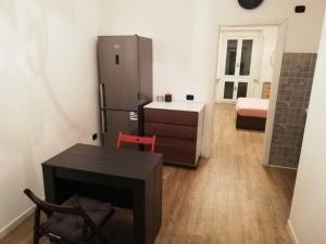 a kitchen with a refrigerator and a table and a desk at CENTRO e PARCO 10 min - flat in Monza in Monza
