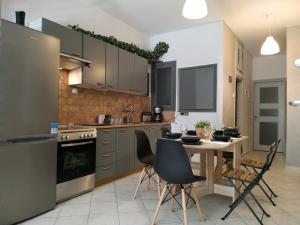 a kitchen with a table and chairs in a kitchen at Bright Apartment steps from the Sea in Thessaloniki