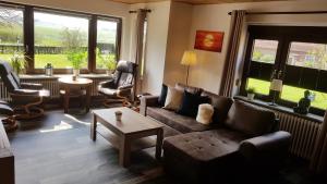 a living room with a couch and chairs and a table at Gästehaus Zur alten Post in Dornumersiel