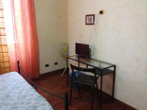 Zimmer mit einem Schreibtisch, einem Computer und einem Stuhl in der Unterkunft Residenza Laterano in Rom