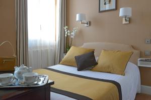 a bedroom with a bed with a tray of tea cups on it at Hotel Splendid in Cannes