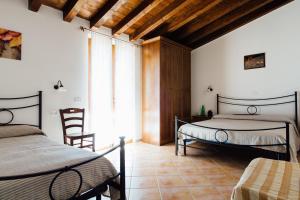丰特博兰达Agriturismo La Sorgente的一间卧室，有两张床、一张桌子和几把椅子