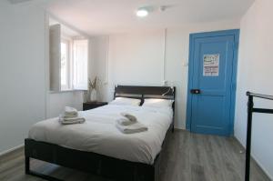 a bedroom with a bed with a blue door at Change The World Hostels - Cascais - Estoril in Monte Estoril