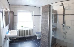 ein Badezimmer mit Dusche, Toilette und Waschbecken in der Unterkunft Gästehaus Zur alten Post in Dornumersiel