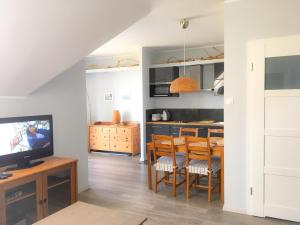 een keuken en eetkamer met een tafel en een televisie bij Widok in Jastrzębia Góra +7 foto's