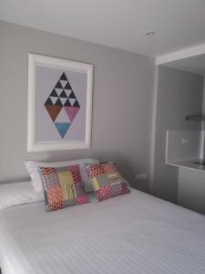 a bedroom with a bed with two pillows and a painting at Apto en Aguadulce con Vistas al Mar in Aguadulce