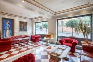 ein Wohnzimmer mit roten Stühlen und einem karierten Boden in der Unterkunft Hotel Villa San Pio in Rom