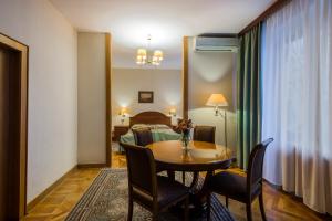 Zimmer mit einem Tisch und Stühlen sowie einem Wohnzimmer in der Unterkunft Arbat Hotel in Moskau