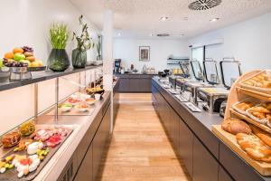 
a kitchen filled with lots of trays of food at Best Western Plus Atrium Hotel in Ulm
