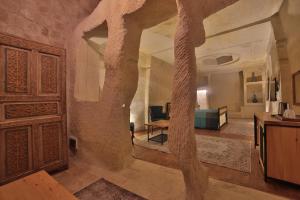 a living room with a large stone archway and a bedroom at Taru Cave Suites in Urgup