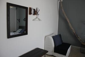 a mirror in a living room with a chair and a couch at Salecce B&B in Lecce