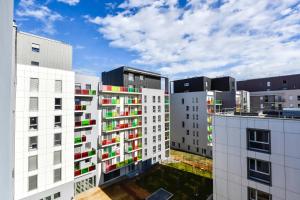 a group of white buildings with colorful windows at Appart hôtel Q7 Lodge Lyon 7 in Lyon