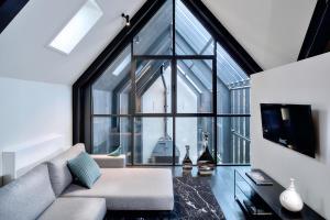 a living room with a couch and a large window at Kazerne Hotel - Member of Design Hotels in Eindhoven