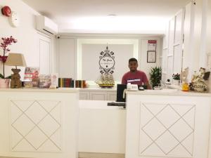 a man sitting at a counter in a room at 52 The Grace hotel in Muar