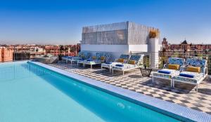a swimming pool with chairs and a view of a city at 2Ciels Boutique Hôtel in Marrakech