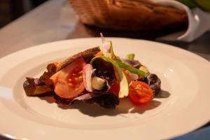 a white plate with a salad on a table at Hotel Jardín Tecina in Playa de Santiago