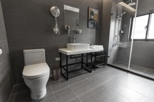 桃園區的住宿－太客旅店，浴室配有卫生间、盥洗盆和淋浴。