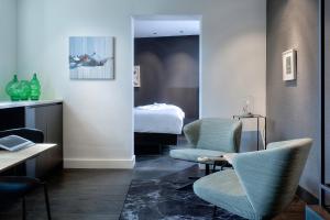ein Hotelzimmer mit zwei Stühlen und einem Bett in der Unterkunft Kazerne Hotel - Member of Design Hotels in Eindhoven + 62 Fotos